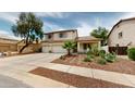 Well-maintained two-story home with a three-car garage, desert landscaping, and mature trees at 10441 W Windsor Ave, Avondale, AZ 85392