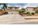 Two-story tan home with a spacious driveway, desert landscaping, and well-maintained curb appeal at 10441 W Windsor Ave, Avondale, AZ 85392