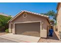 Rear exterior of the home showcasing a two-car garage and low maintenance yard at 125 N 22Nd Pl # 53, Mesa, AZ 85213