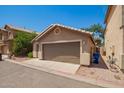 Rear exterior of the home showcasing a two-car garage and low maintenance yard at 125 N 22Nd Pl # 53, Mesa, AZ 85213