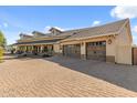 Home with spacious 3-car garage, brick driveway, and lovely landscaping at 1409 E Dove Pl, Casa Grande, AZ 85122