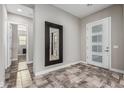 Welcoming foyer featuring a stylish front door with sidelights and a decorative mirror accentuating the neutral color palette at 1725 E Everglade Ln, Gilbert, AZ 85298