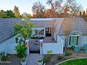 Aerial view of a home with a terra cotta roof, white walls, wrought iron gate and lush landscaping at 18 W Kaler Dr, Phoenix, AZ 85021