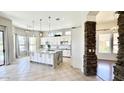 Open-concept kitchen features a large island, white cabinetry, and modern lighting fixtures at 20906 N 56Th Dr, Glendale, AZ 85308