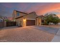 Two-story home featuring a two car garage, desert landscaping, and a fenced yard at 2324 W Melody Dr, Phoenix, AZ 85041