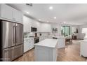 Modern kitchen with white cabinets, stainless steel appliances, island, and wood floors at 2511 W Queen Creek Rd # 174, Chandler, AZ 85248