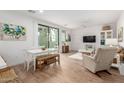 Bright living room with white furniture, wood floors, and a sliding glass door to a patio at 2511 W Queen Creek Rd # 174, Chandler, AZ 85248