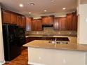 Well-lit kitchen features granite countertops, dark wood cabinets, and stainless steel appliances at 26449 N 84Th Dr, Peoria, AZ 85383