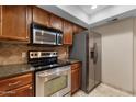 Updated kitchen features stainless steel appliances and granite countertops at 3235 E Camelback Rd # 124, Phoenix, AZ 85018
