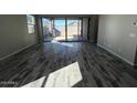 Bright, airy living room features wood-look tile floors and a sliding glass door to the backyard at 3248 W San Cristobal Rd, San Tan Valley, AZ 85144