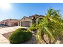 Charming home with a three-car garage, tile roof, neutral colors, and desert landscaping at 4214 W Marco Polo Rd, Glendale, AZ 85308