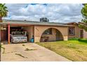 Cozy home featuring a covered carport, arched entryway, and well-kept lawn at 4438 W Hatcher Rd, Glendale, AZ 85302