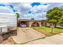 Quaint home with a covered carport, mature landscaping, and a welcoming facade at 4438 W Hatcher Rd, Glendale, AZ 85302