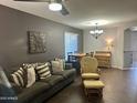 Comfortable living room with wood flooring, sofa with pillows, and a view into the dining area at 491 E Jeanne Ln, San Tan Valley, AZ 85140