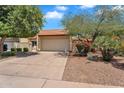 Inviting home exterior boasting a two-car garage, desert landscaping, and mature trees, enhancing curb appeal at 560 W Duke Dr, Tempe, AZ 85283