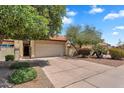 Well-kept home with a two-car garage, mature trees, and desert landscaping, offering a welcoming facade at 560 W Duke Dr, Tempe, AZ 85283