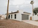 Exterior view of the home showcasing a garage and desert landscaping at 6401 E Eugie Ter, Scottsdale, AZ 85254