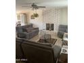 Comfortable living room features a brick fireplace, ceiling fan, neutral paint and tile floors at 8307 W Indianola Ave, Phoenix, AZ 85037