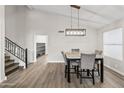 Bright dining area with modern light fixture, marble table, and stylish gray chairs with access to the staircase at 8912 W Sheridan St, Phoenix, AZ 85037