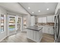 Bright kitchen with white cabinetry, an island, stainless steel appliances, and a door to the backyard deck at 8912 W Sheridan St, Phoenix, AZ 85037