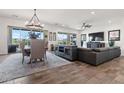 Open concept living room with wood floors, dining area and sliding glass doors at 11249 N Blakely St, Surprise, AZ 85388