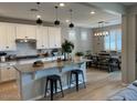 Bright kitchen features white cabinets, granite countertops, stainless steel appliances and an island at 11403 W Ashby Dr, Peoria, AZ 85383