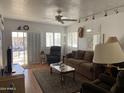 Inviting living room featuring cozy brown sofa, recliner, ceiling fan and laminate wood flooring at 1318 W Chesapeake Dr, Apache Junction, AZ 85119