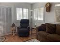 Comfortable living room with shutters on windows, brown sofa, and cozy recliner at 1318 W Chesapeake Dr, Apache Junction, AZ 85119