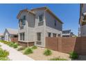 Side view of home featuring a desert landscape, block fence, and neutral color palette at 14231 W Bronco Trl, Surprise, AZ 85387