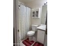 Bathroom with white vanity, toilet, and shower with white curtain at 14922 W Port Au Prince Ln, Surprise, AZ 85374