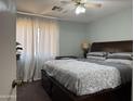 Cozy bedroom featuring a comfortable king-sized bed, ceiling fan, and bright natural light at 14922 W Port Au Prince Ln, Surprise, AZ 85374