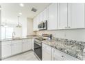 Modern kitchen with stainless steel appliances, granite countertops, and white cabinets at 15120 S Amado Blvd, Arizona City, AZ 85123