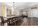 Bright dining area featuring a modern light fixture, a long dining table, and wood floors at 17606 N 2Nd Ave, Phoenix, AZ 85023