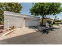 Contemporary home featuring a two car garage and desert landscaping with a mature tree at 225 W Winged Foot Rd, Phoenix, AZ 85023