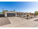 Charming single-story home exhibiting desert landscaping and a spacious driveway, perfect for suburban living at 3010 E Yucca St, Phoenix, AZ 85028