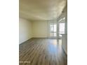 Bright living room featuring modern wood flooring and natural light from a window at 3828 N 32Nd St # 213, Phoenix, AZ 85018