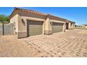 A desert home featuring a three-car garage, low maintenance landscape, and a paver driveway at 3850 N Mateo Dr, Eloy, AZ 85131