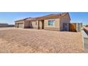 Side view of a desert home featuring a three-car garage, low maintenance landscape, and a paver driveway at 3850 N Mateo Dr, Eloy, AZ 85131