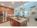 Open-concept kitchen with a large island, stainless steel appliances, and views of the dining area at 3855 S Mcqueen Rd # 12, Chandler, AZ 85286