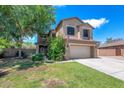 Inviting two-story home with a lush green lawn and mature landscaping creating a warm curb appeal at 5787 W Barbara Ave, Glendale, AZ 85302