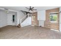 Bright living room with wood look floors, stylish ceiling fan, and staircase leading to the upper level at 5787 W Barbara Ave, Glendale, AZ 85302