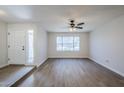Bright living room with hardwood floors, a ceiling fan, and a large window overlooking the front yard at 6214 W Sunnyside Dr, Glendale, AZ 85304