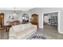 Open-concept living area featuring elegant wood flooring, a formal dining area, and comfortable seating at 6915 E Lakeview Ave, Mesa, AZ 85209