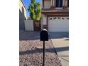 View of the driveway and garage of a house with desert landscaping at 6928 W Oraibi Dr, Glendale, AZ 85308