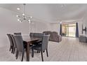 Bright dining area with modern lighting and easy access to the living room and backyard sliding door at 7086 W Spur Dr, Peoria, AZ 85383