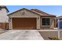 Charming single-story home with a brown garage door, desert landscaping, and a tile roof at 7086 W Spur Dr, Peoria, AZ 85383