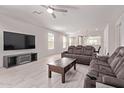 Modern living room featuring tile floors, media center, ceiling fan, and reclining sofa at 7086 W Spur Dr, Peoria, AZ 85383