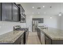 Kitchen with granite countertops, stainless steel appliances and dark wood cabinets at 8518 S 8Th Ln, Phoenix, AZ 85041