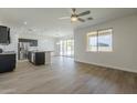 Spacious living room featuring wood floors, a ceiling fan and sliding glass doors at 8518 S 8Th Ln, Phoenix, AZ 85041
