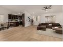 Open-concept living room with wood floors, brown sectional sofa, kitchen view, and a bright interior at 908 W Mohawk Ln, Phoenix, AZ 85027